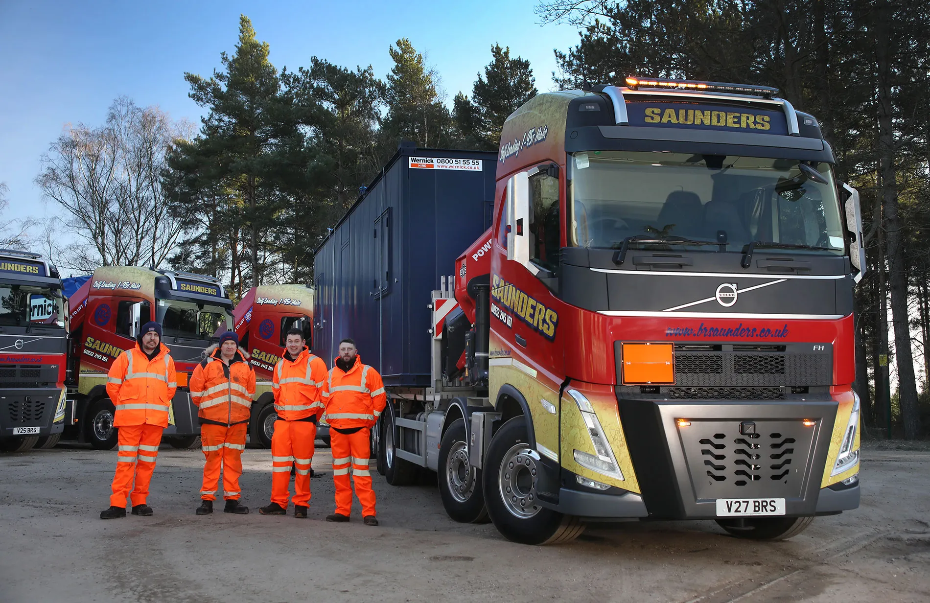 A group of men standing next to a truck.