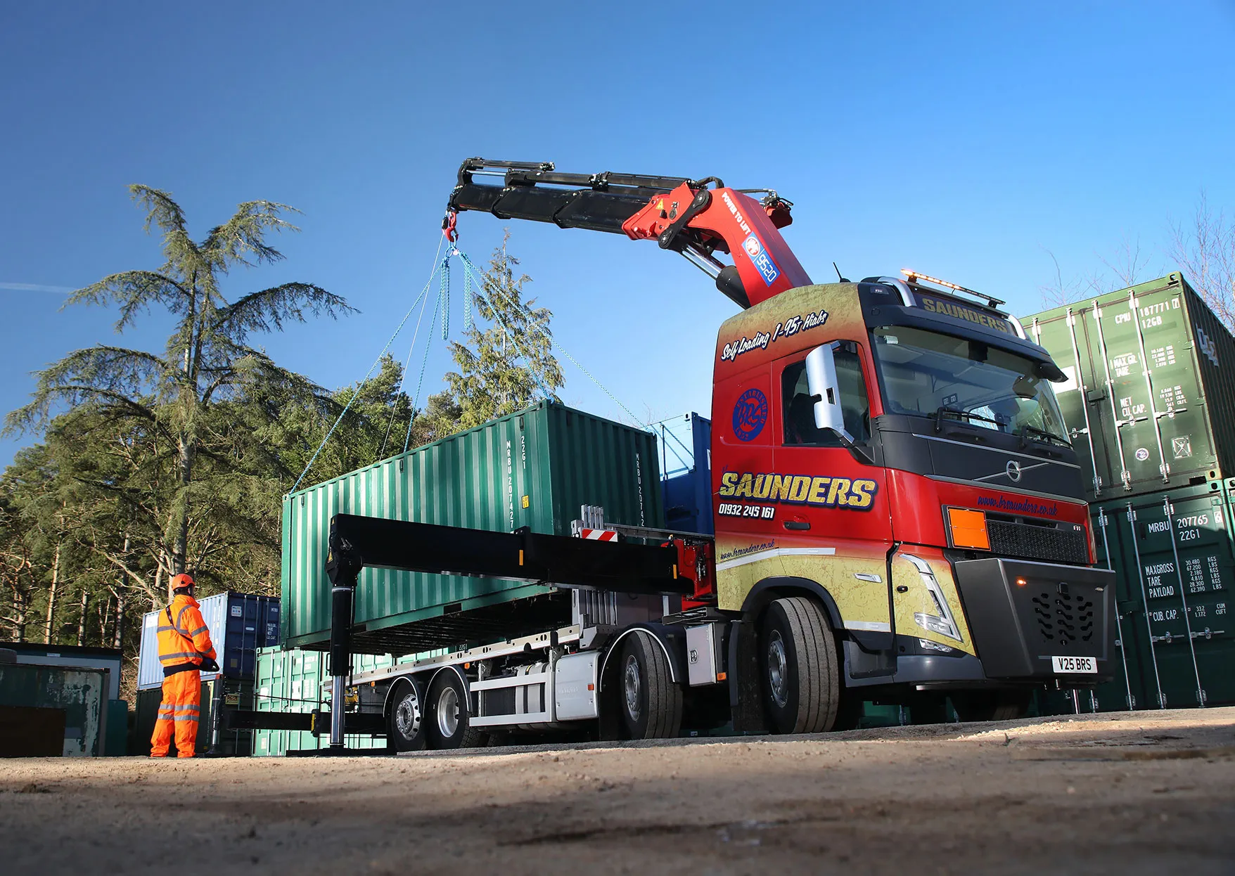 A red and yellow truck with a crane on top of it.
