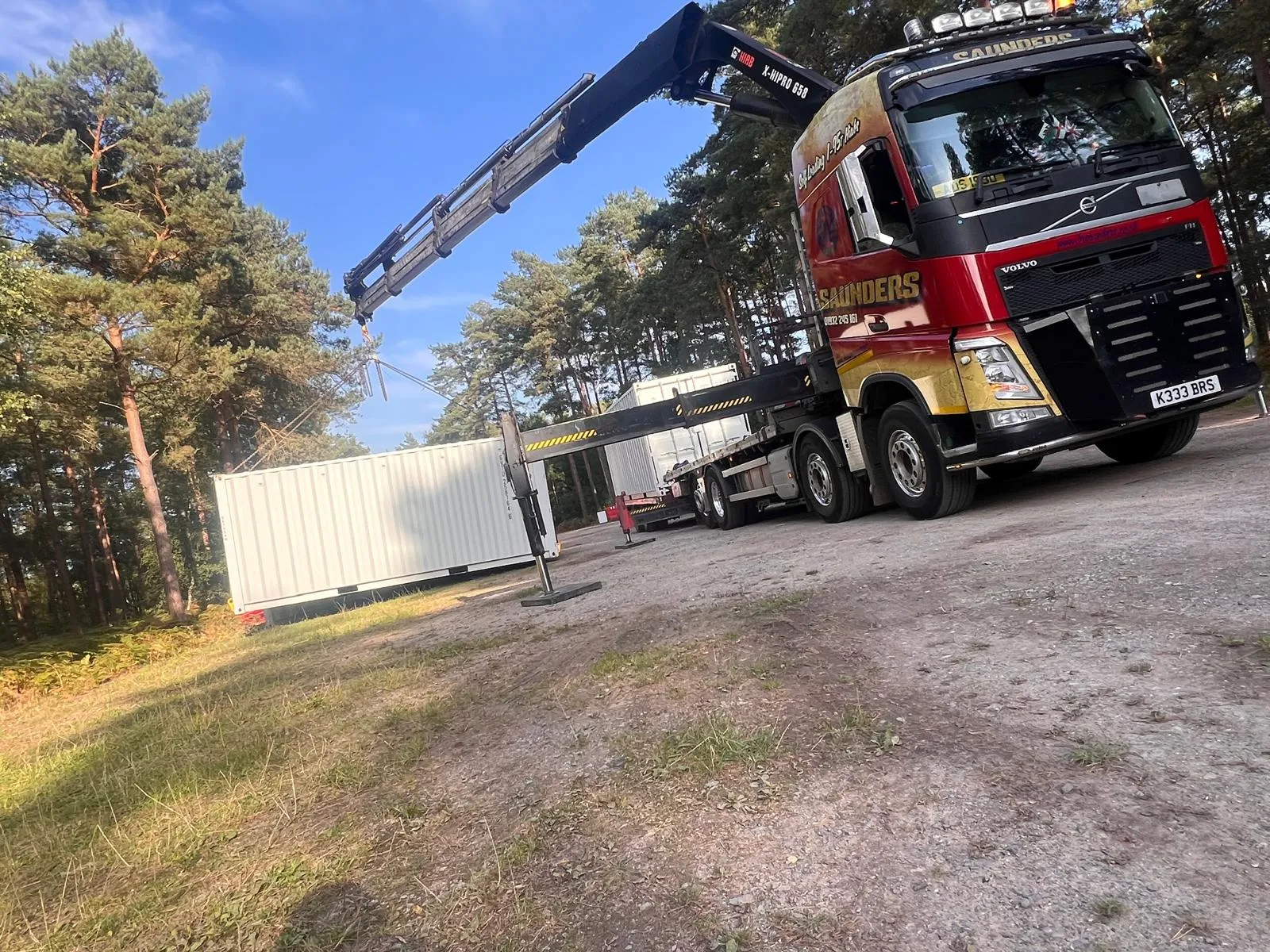 A red and yellow truck with a crane on top of it.