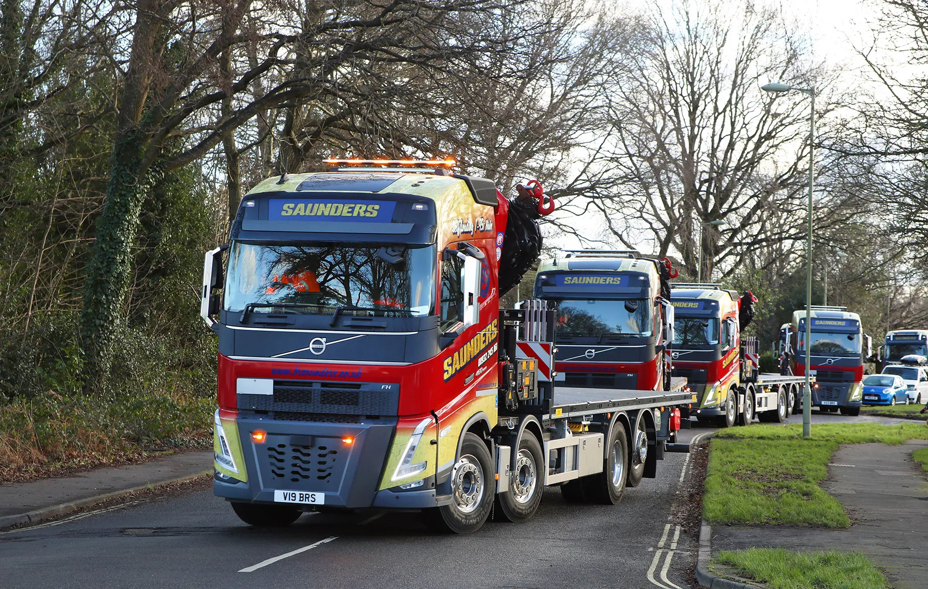 A tow truck carrying a large load down a street.