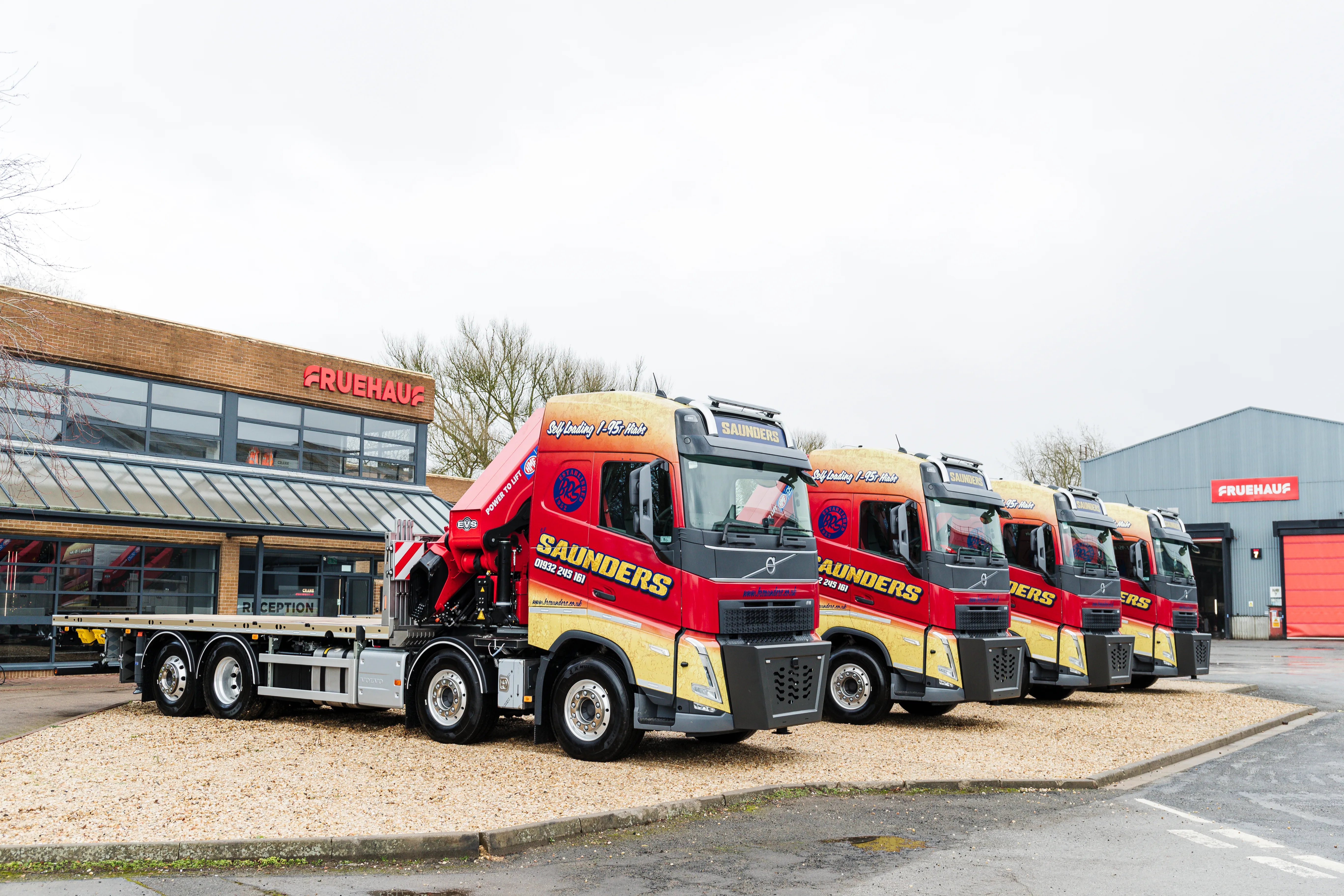 A row of trucks parked in front of a building.
