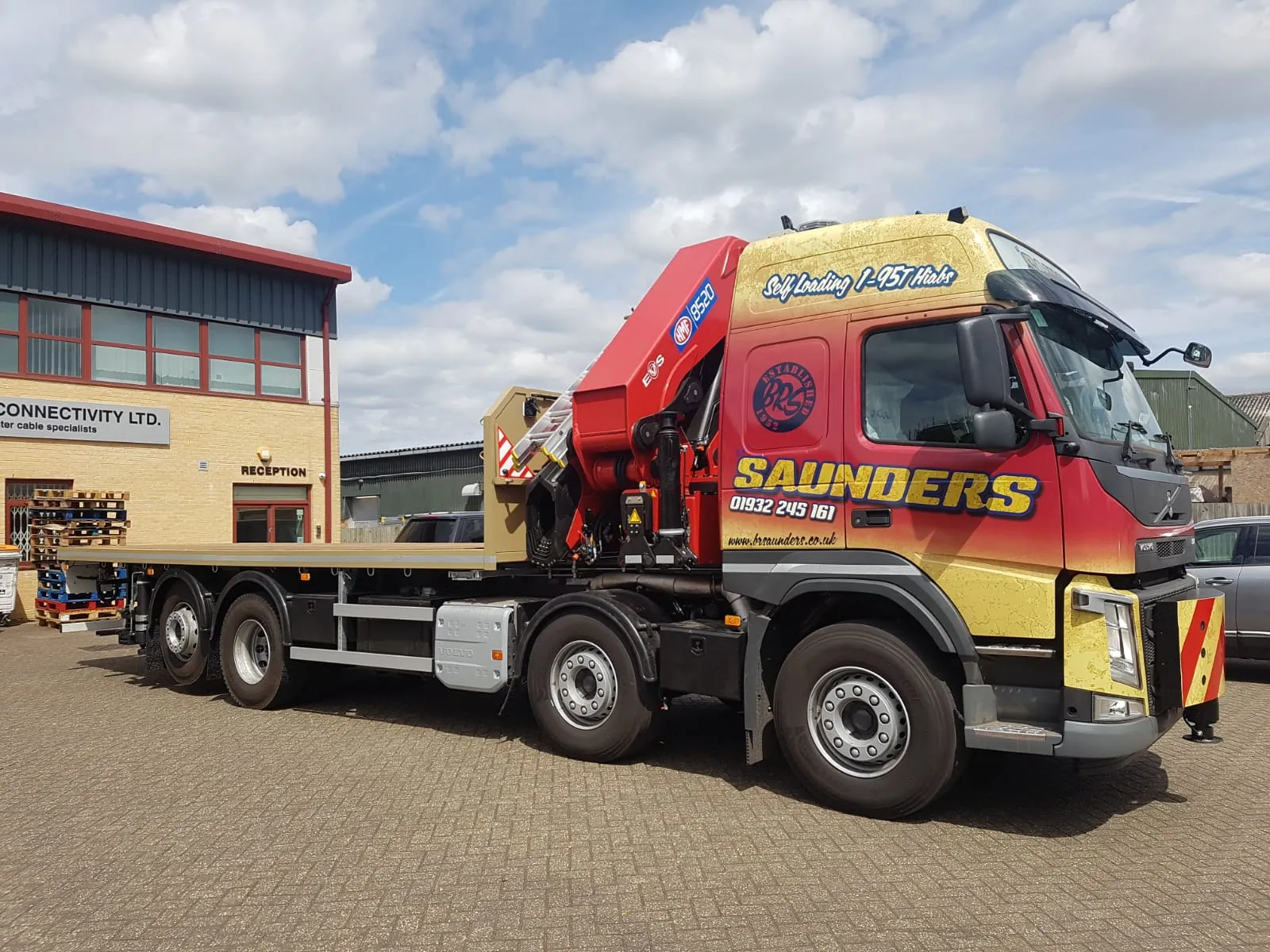 A red and yellow truck parked in front of a building.